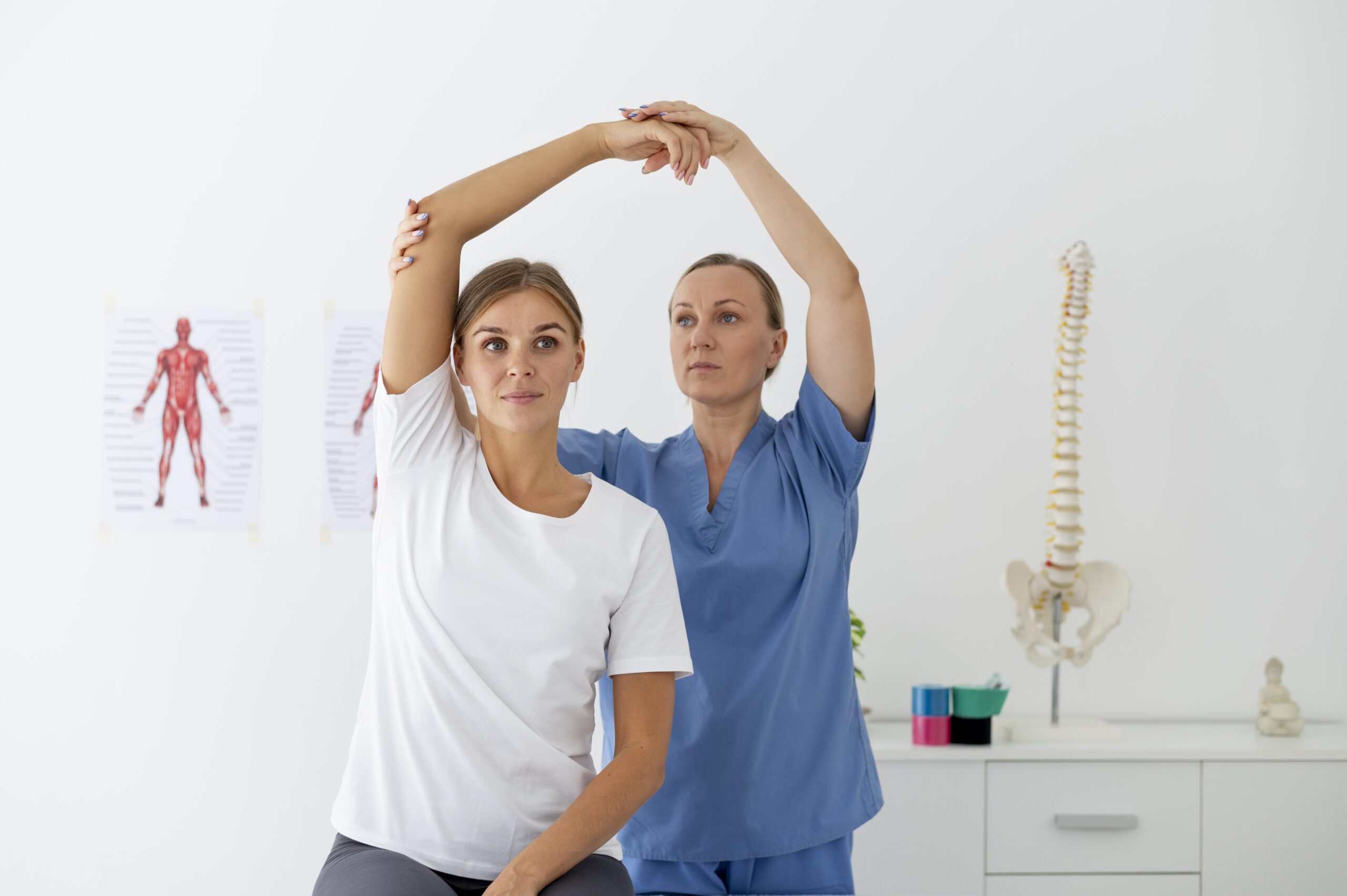 A female physiotherapist at a NeuroRehab Clinic in Calgary is stretching her arms in front of a patient.